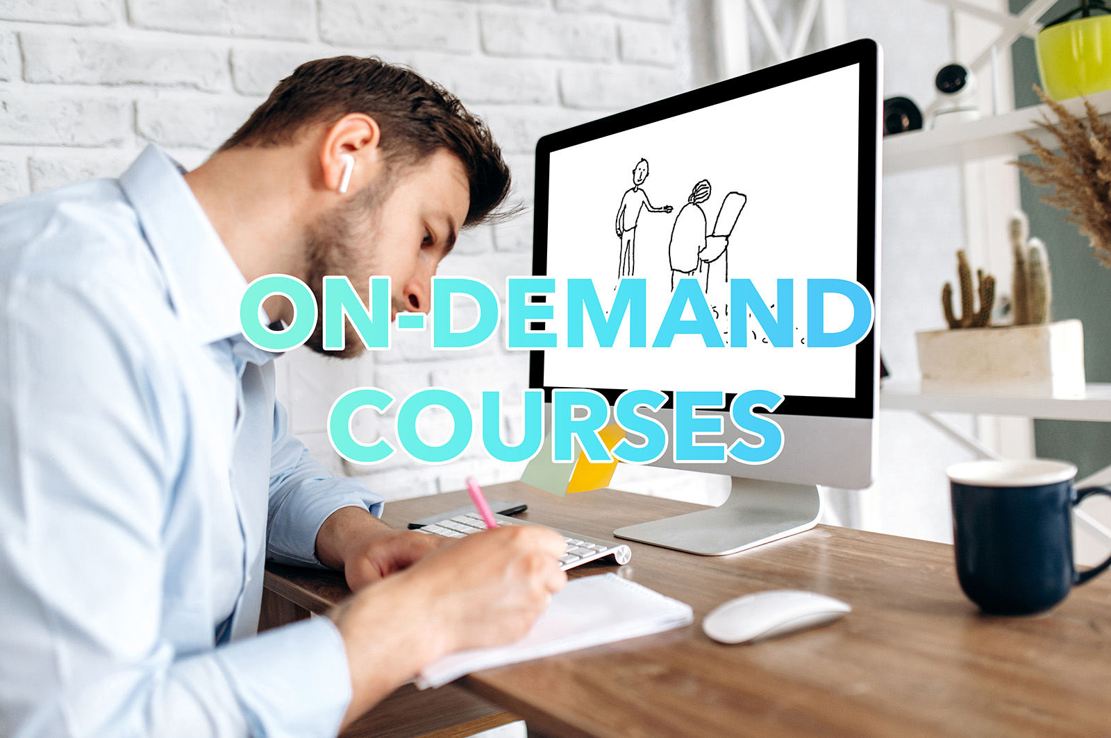 A man is taking notes while looking at a computer screen.